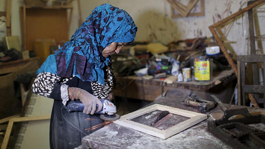 Palestinian carpenter Amal Abu Regaiq, 43, works at her workshop in Nuseirat in the central Gaza Strip August 30, 2015. Abu Regaiq designs picture frames and sells them in the markets of the narrow enclave.   REUTERS/Ibraheem Abu Mustafa - RTX1Q9CG