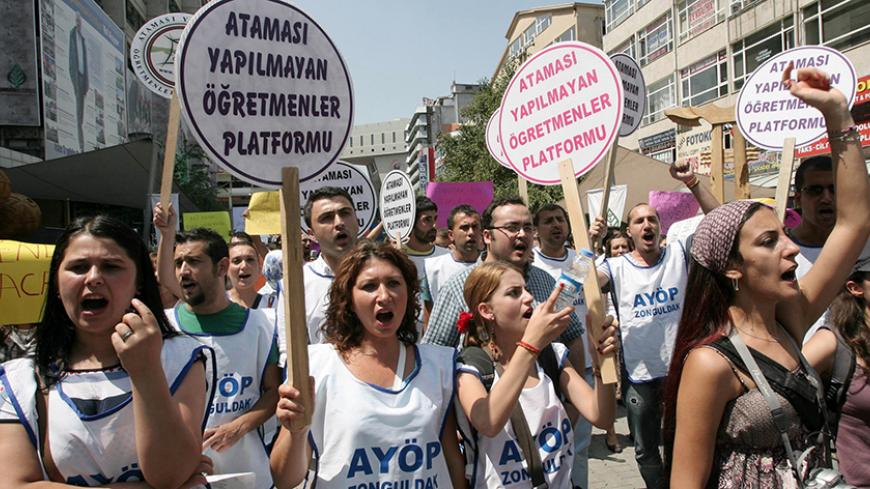 Unemployed teachers display banners which translate as  "We want unconditional appointment"  and "We will resist and win." during a demonstration in Ankara on August 4, 2012.  The teachers gathered to demand jobs as unemployment in the profession increases.   AFP PHOTO/ADEM ALTAN        (Photo credit should read ADEM ALTAN/AFP/GettyImages)