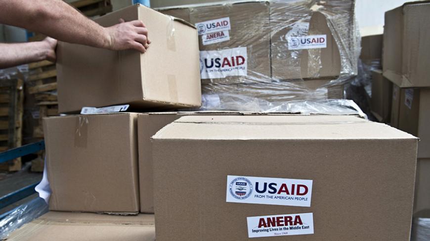 A UN worker takes a box containing sanitation kits and soap provided by the United States Agency for International Development (USAID) being stored at a UN school before a distribution to Palestinian displaced people on August 15, 2014 in Gaza City. The United Nations estimates that some 10,000 Palestinian homes were destroyed during fighting between Israel and Hamas during more than 4 weeks displacing hundreds of thousands from their homes in Gaza. A fragile ceasefire around Gaza held for a second day Frid