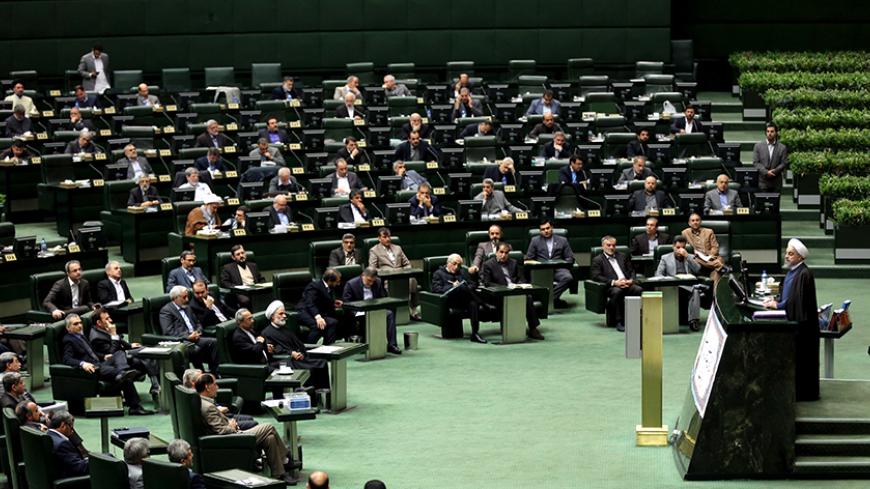 Iranian President Hassan Rouhani (R) delivers a speech to parliament before presenting the proposed annual budget in Tehran on December 7, 2014. Iran's parliament has adopted a law on December 4, to tax religious foundations and military-linked companies, a first for the Islamic republic that could generate hundreds of millions of dollars in revenues, media reported. AFP PHOTO/ATTA KENARE        (Photo credit should read ATTA KENARE/AFP/Getty Images)