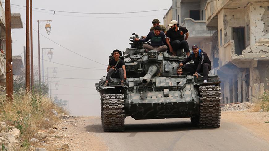 TOPSHOT - Opposition fighters drive a tank in a rebel-held area of the southern Syrian city of Daraa, during re-newed clashes with regime loyalists on May 10, 2016. / AFP / MOHAMAD ABAZEED        (Photo credit should read MOHAMAD ABAZEED/AFP/Getty Images)