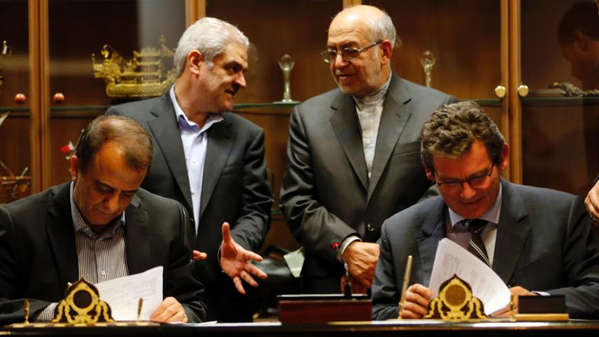 Deputy of France's Peugeot Citroen (PSA) Jean-Christophe Quemard,(R) signs documents with CEO of industrial group Iran Khodro, Hachem Yekehzare (L), as Iran's Industry and Commerce Minister Mohammad Reza Nematzadeh (2R) watches on in Tehran on June 21, 2016.
PSA is the first Western carmaker to announce a return to Iran since many economic sanctions were lifted in January when a landmark nuclear deal with world powers took effect.
 / AFP / ATTA KENARE        (Photo credit should read ATTA KENARE/AFP/Getty I