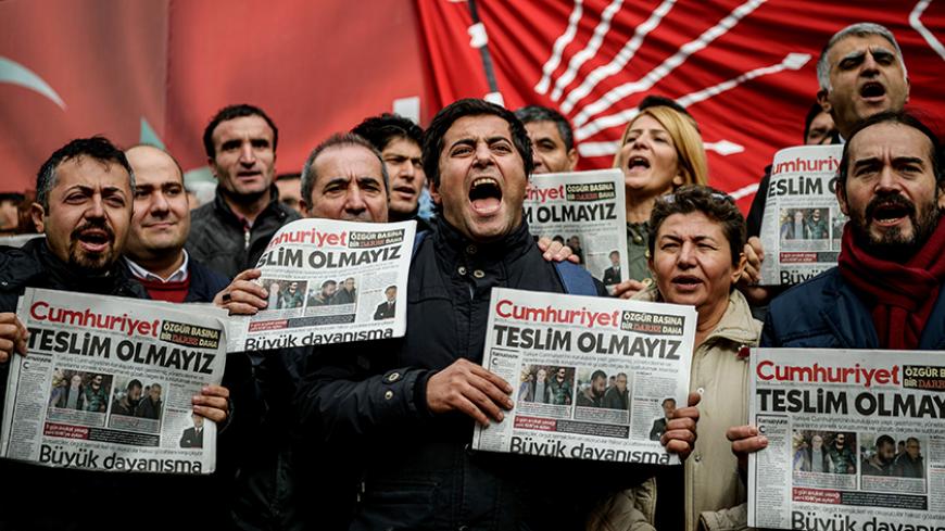 TOPSHOT - Protesters hold copies of the latest edition of the the Turkish daily newspaper "Cumhuriyet" as they shout slogans during a demonstration outside the newspaper's headquarters in Istanbul on November 1,2016 a day after its editor in chief was detained by police. 
Turkish police detained the editor-in-chief of the opposition newspaper Cumhuriyet, state media reported, while the daily said several of its writers were taken into police custody. Murat Sabuncu was detained while authorities searched for