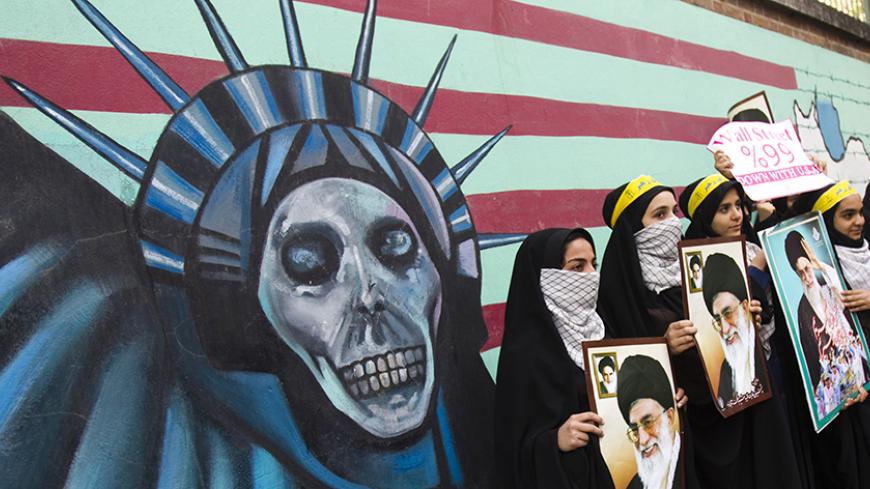 EDITORS' NOTE: Reuters and other foreign media are subject to Iranian restrictions on their ability to film or take pictures in Tehran.

Iranian students holding pictures of Iran's Supreme Leader Ayatollah Ali Khamenei stand in front of an anti U.S. mural, painted on the wall of the former U.S. Embassy in Tehran November 4, 2011. REUTERS/Raheb Homavandi  (IRAN - Tags: POLITICS) - RTR2TLUF
