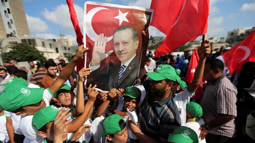 Palestinians hold a poster of Turkish President Tayyip Erdogan during a Hamas rally in support of Erdogan's government against a coup attempt, in Khan Younis in the southern Gaza Strip July 16, 2016. REUTERS/Ibraheem Abu Mustafa     TPX IMAGES OF THE DAY      - RTSI917