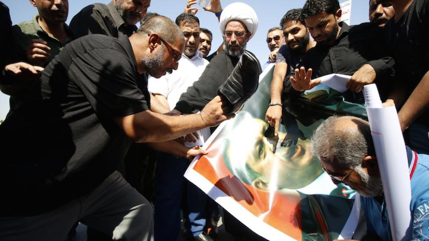 Protesters tear up a picture of Turkey's President Tayyip Erdogan in Basra, Iraq October 14, 2016. REUTERS/Essam Al-Sudani - RTSS82L