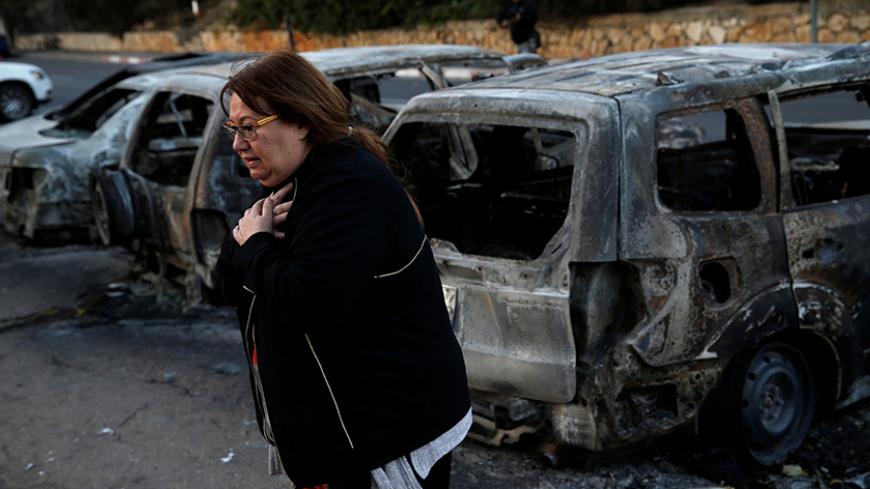 A resident stands next to burnt cars from Thursday's fire in the northern city of Haifa, Israel November 25, 2016. REUTERS/Baz Ratner - RTST83G
