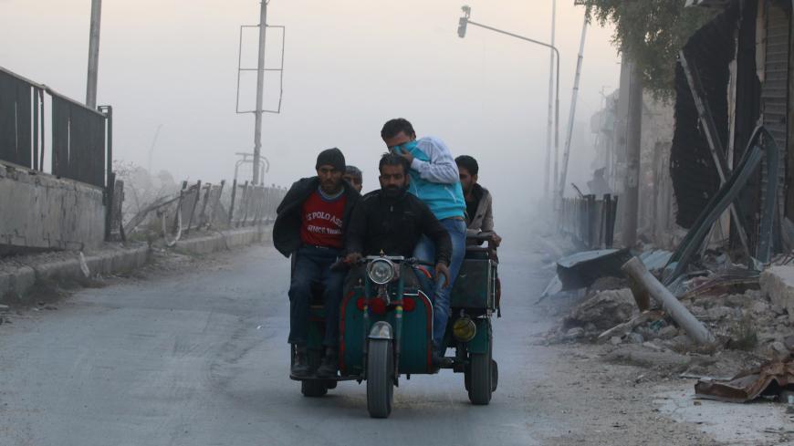 Men ride on a vehicle amidst dust after a strike on the rebel held besieged al-Shaar neighbourhood of Aleppo, Syria, November 26, 2016. REUTERS/Abdalrhman Ismail - RTSTFC7