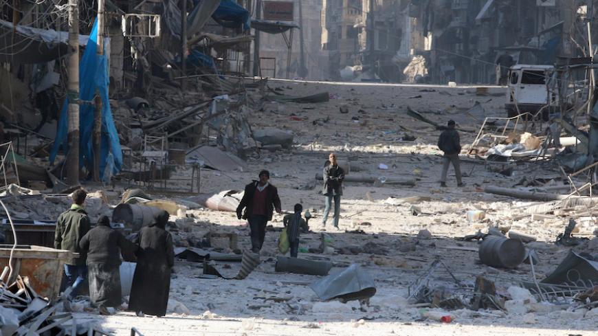 Syrians walk over rubble of damaged buildings, while carrying their belongings, as they flee clashes between government forces and rebels in Tariq al-Bab and al-Sakhour neighborhoods of eastern Aleppo towards other rebel held besieged areas of Aleppo, Syria November 28, 2016. REUTERS/Abdalrhman Ismail - RTSTOFV