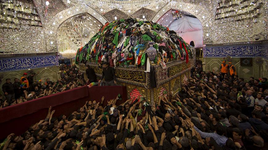 Shi'ite Muslim pilgrims reach out to touch the tomb of Imam al-Abbas located inside the Imam al-Abbas shrine to mark Arbaeen, in the holy city of Kerbala, southwest of Baghdad, December 3, 2015. REUTERS/Ahmed al-Husseini TPX IMAGES OF THE DAY - RTX1X0XY