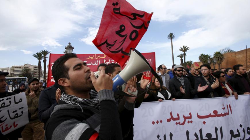 A man waves a sign during a demonstration called by the February 20 protest movement to mark the sixth anniversary of the movement and to demand political reforms and social changes in Rabat February 20, 2016. REUTERS/Youssef Boudlal  - RTX27UUB