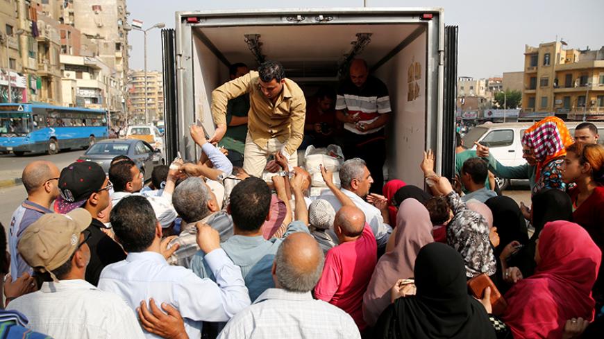 Egyptians push to buy subsidized sugar from a government truck after a sugar shortage in retail stores across the country in Cairo, Egypt, October 14, 2016. Picture taken October 14, 2016.   REUTERS/Amr Abdallah Dalsh - RTX2PEL1