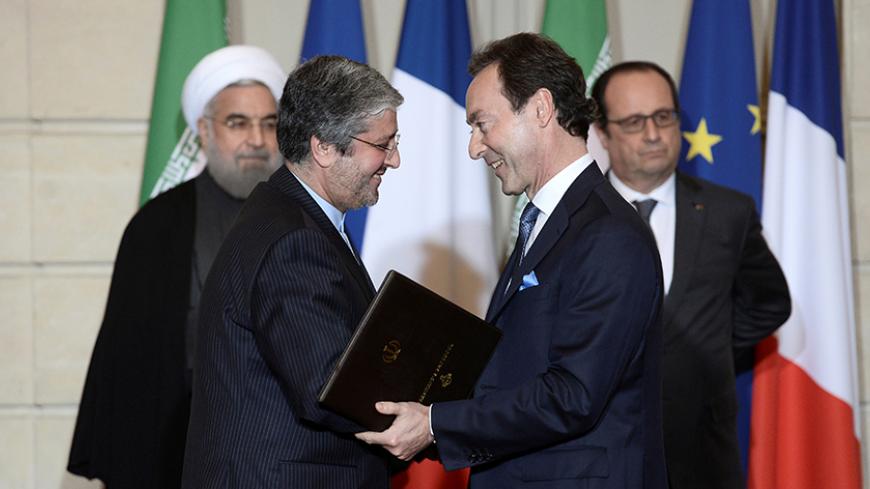 Airbus chief executive Fabrice Bregier (R), Iran Air chief Executive Farhad Parvaresh (L), Iranian President Hassan Rouhani (rear L) and French President Francois Hollande attend a bilateral political, cultural and economic agreements signing ceremony at the Elysee Palace in Paris, France, January 28, 2016.REUTERS/Stephane De Sakutin/Pool/Files - RTX2SAMN