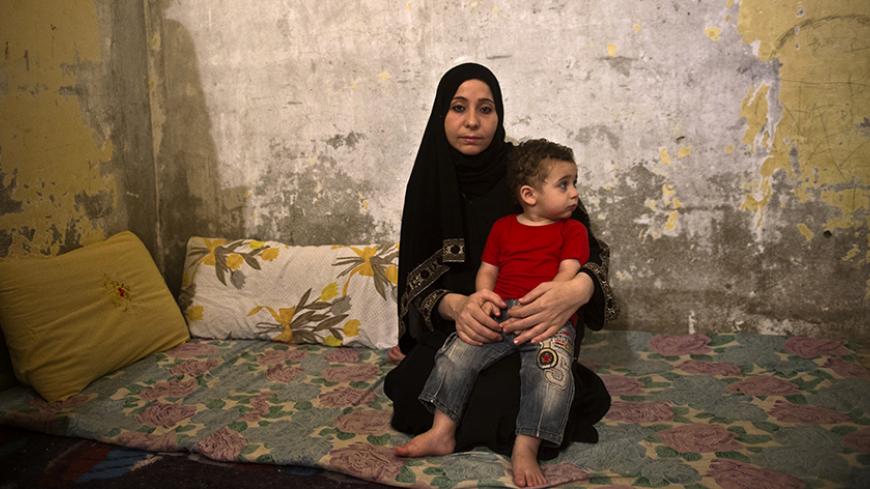 Syrian refugee Reem al-Sawaa, 28, originally from Daraa in southern Syria, sits with her one-year-old son Khaled at their home in the Helwaan district of the Egyptian capital of Cairo on November 1, 2013. Reem fled Syra with her four children and husband Yussef al-Talha, who works as a computer technician.  AFP PHOTO / KHALED DESOUKI        (Photo credit should read KHALED DESOUKI/AFP/Getty Images)