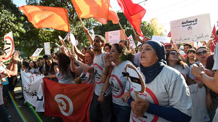 Tunisians shout slogans on July 25, 2016 on Habib Bourguiba Avenue in the capital Tunis during a demonstration against a bill being discussed in parliament to grant amnesty to people accused of corruption.
If the so-called "economic reconciliation" bill is passed into law people accused of corruption would not be prosecuted but would instead pay a fine and reimburse embezzled funds. When the bill was submitted to parliament last year by President Beji Caid Essebsi it spart outrage in Tunisia, with demonstra