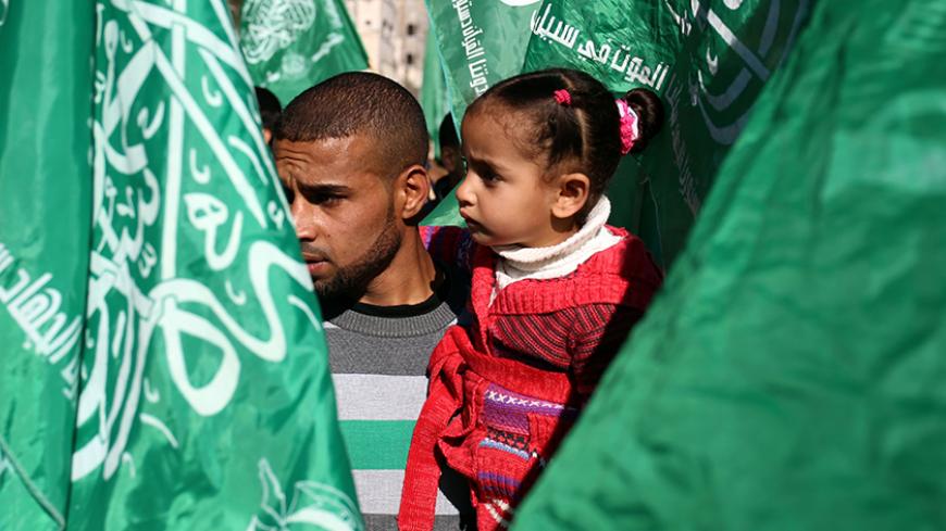 Supporters of the Palestinian Hamas movement stand between Hamas movement flags as they attend a rally to commemorate the 29th anniversary of the movement on the streets of the Jabalia refugee camp in the northern Gaza Strip on December 9, 2016. / AFP / MOHAMMED ABED        (Photo credit should read MOHAMMED ABED/AFP/Getty Images)