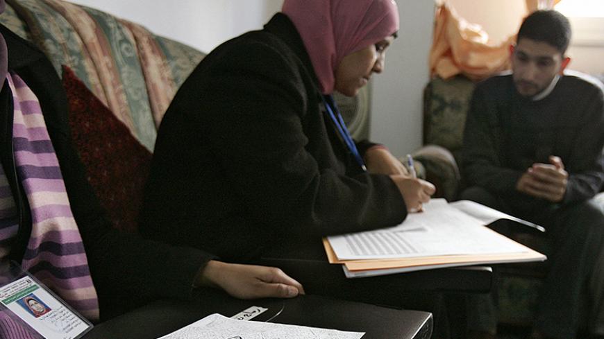 An employee from the Palestinian statistics department completes a form for the Palestinian population census during house-to-house visits in the West Bank city of Ramallah, 01 December 2007. The Palestinian Authority began today the first population census in the territories since 1997. AFP PHOTO/Abbas MOMANI (Photo credit should read ABBAS MOMANI/AFP/Getty Images)