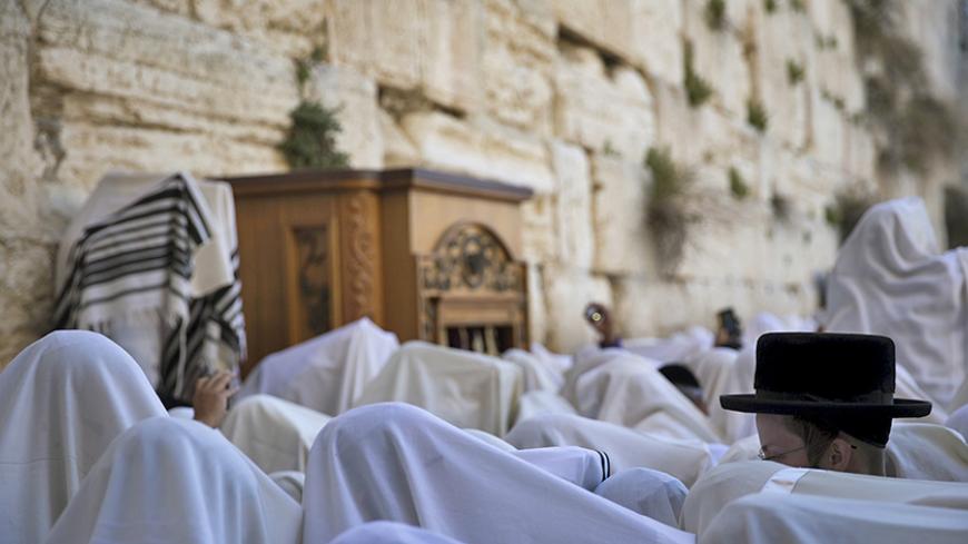 Jewish worshippers covered with prayer shawls take part in a special priestly blessing for Passover at the Western Wall, Judaism's holiest prayer site, in Jerusalem's Old City April 6, 2015. REUTERS/Ronen Zvulun  - RTR4W8AE