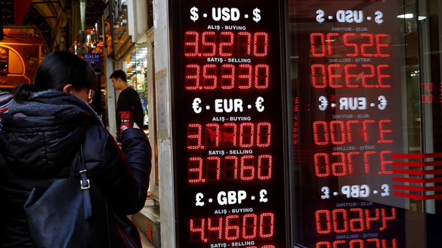 A woman uses her mobile phone to take a picture of a display board at a currency exchange office at the Grand Bazaar in Istanbul, Turkey, December 5, 2016. Picture taken December 5, 2016. REUTERS/Murad Sezer - RTSUWLI
