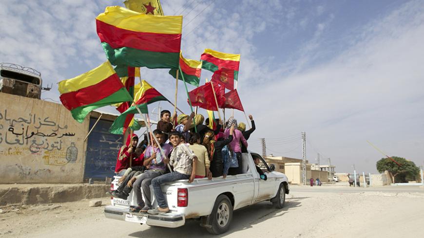 People sit in the back of a truck as they celebrate what they said was the liberation of villages from Islamist rebels near the city of Ras al-Ain in the province of Hasakah, after capturing it from Islamist rebels November 6, 2013. Redur Xelil, spokesman for the armed wing of the Syrian Kurdish Democratic Union Party (PYD), said Kurdish militias had seized the city of Ras al-Ain and all its surrounding villages. Syrian Kurdish fighters have captured more territory from Islamist rebels in northeastern Syria