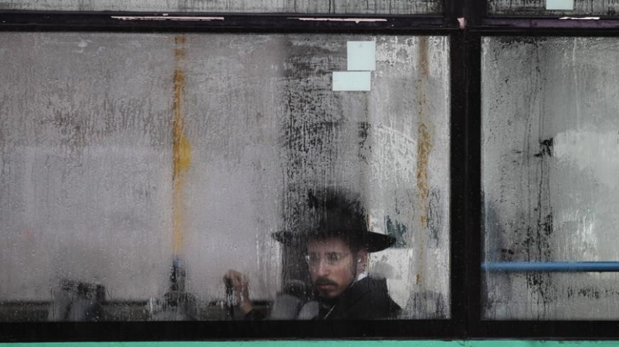 An ultra-Orthodox Jewish man looks out from a condensation-covered window of a bus in Jerusalem December 11, 2013. High winds and heavy rain showers poured across Israel on Wednesday with local media reporting by mid-morning 45 mm of rain in a central town near Tel Aviv, and snow had covered Mount Hermon near Israel's border with Syria. REUTERS/Ammar Awad (JERUSALEM - Tags: ENVIRONMENT SOCIETY TPX IMAGES OF THE DAY) - RTX16DZI