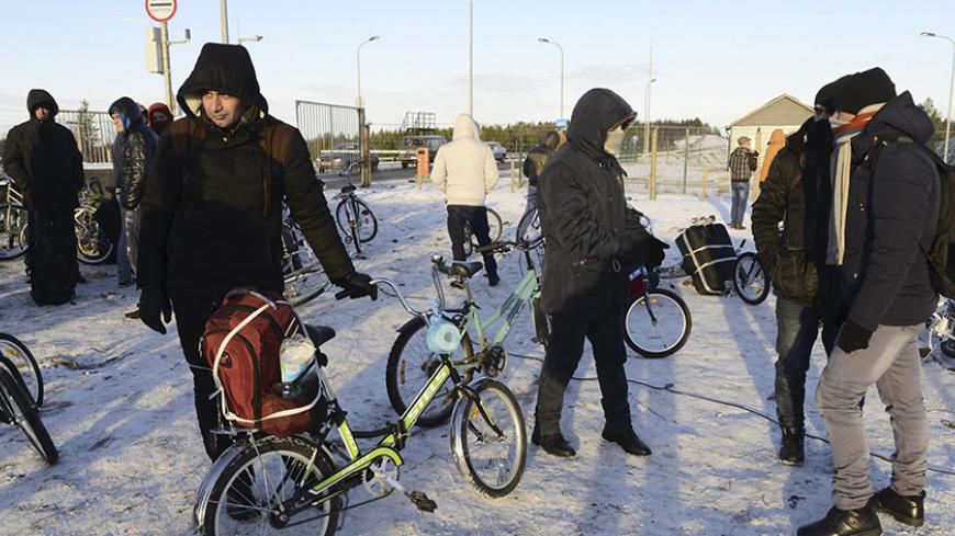 Refugees and migrants gather near a check point on the Russian-Norwegian border outside Nickel (Nikel) settlement in Murmansk region, Russia, October 30, 2015. The flow of Middle Eastern migrants trying to reach Europe via the Russian Arctic slowed dramatically on October 29, partly due to a shortage of bicycles to cross the border, a source who deals with them told Reuters. According to officials, many Syrians obtain business or study visas to enter Russia and then travel through Moscow and Murmansk to Nic