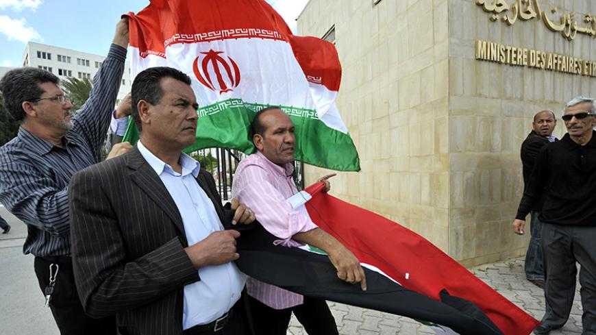 Tunisian protestors hold the Iranian and the Syrian flags as they demonstrate outside the Ministry of Foreign Affairs on May 28, 2013 in Tunis, calling on their Islamist-led government to renew diplomatic relations with Syria and the regime of Bashar al-Assad. AFP PHOTO / FETHI BELAID        (Photo credit should read FETHI BELAID/AFP/Getty Images)