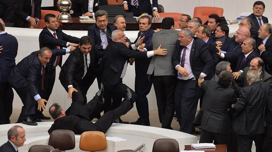 Lawmakers from the main opposition Republican People's Party (CHP) and ruling AK Party (R) scuffle during a debate on a legislation to boost police powers, at the Turkish Parliament in Ankara late February 19, 2015 AFP PHOTO/ADEM ALTAN        (Photo credit should read ADEM ALTAN/AFP/Getty Images)