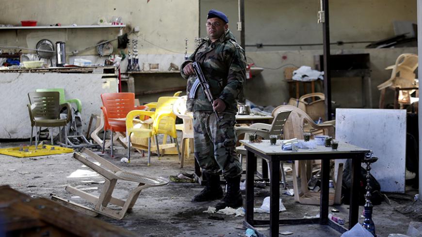A Lebanese Army soldier stand guard inside a cafe where a suicide bomb attack took place in Jabal Mohsen, Tripoli January 11, 2015. At least seven people were killed after a cafe was attacked by a suicide bomber in the Lebanese city of Tripoli on Saturday. The al Qaeda-linked Nusra Front claimed responsibility for the attack on a Twitter account describing it as revenge for the Sunnis in Syria and Lebanon. REUTERS/Hasan Shaaban (LEBANON - Tags: POLITICS CIVIL UNREST MILITARY) - RTR4KW9O