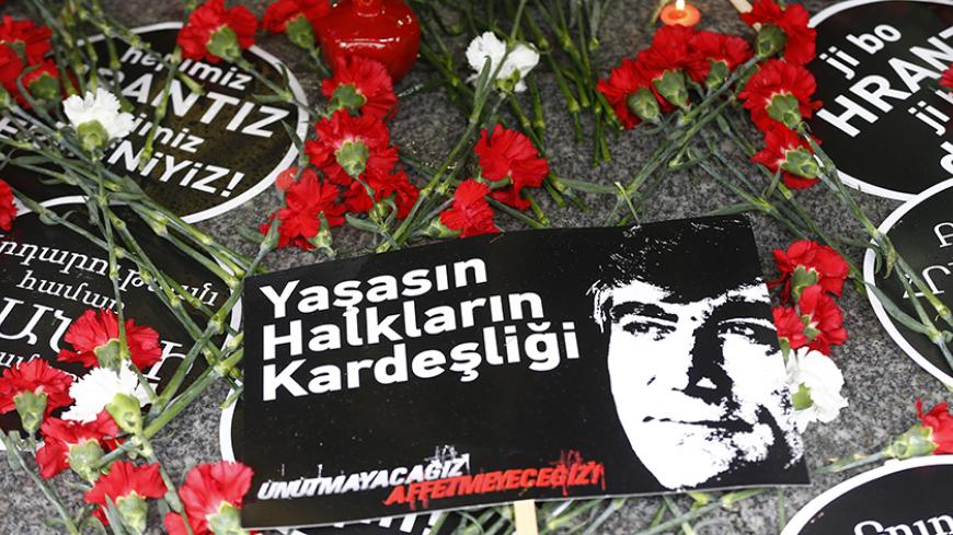 Carnations and placards are laid on the spot, where Turkish-Armenian journalist Hrant Dink was killed, during a commemoration to mark the 10th anniversary of his death, in Istanbul, Turkey, January 19, 2017. The placard reads that: "Long live the brotherhood of people. We will not forget, we will not forgive". REUTERS/Osman Orsal - RTSW8ZI