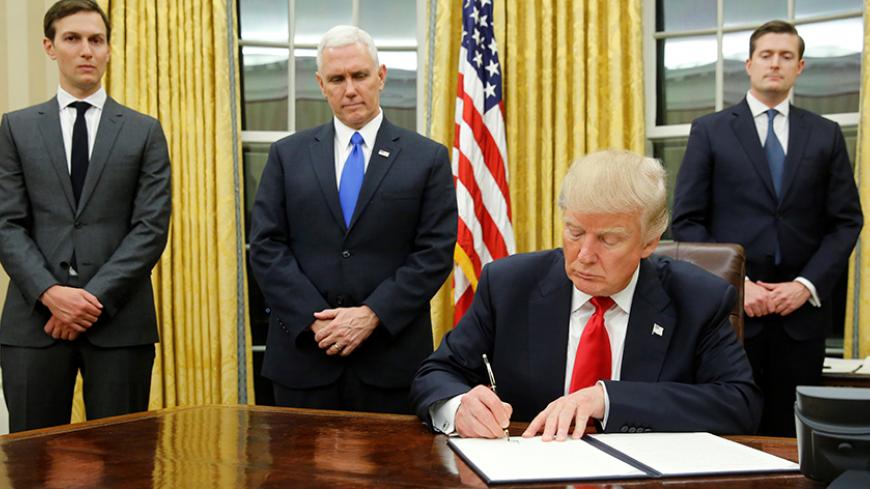 U.S. President Donald Trump, flanked by Senior Advisor Jared Kushner (standing, L-R), Vice President Mike Pence and Staff Secretary Rob Porter welcomes reporters into the Oval Office for him to sign his first executive orders at the White House in Washington, U.S. January 20, 2017. REUTERS/Jonathan Ernst     TPX IMAGES OF THE DAY - RTSWLVK