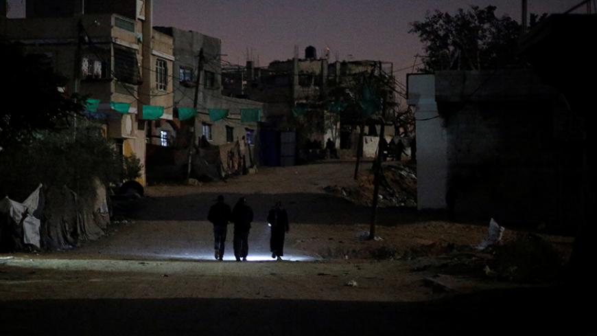 Palestinians walk on a road during a power cut in Beit Lahiya in the northern Gaza Strip January 11, 2017. Picture taken January 11, 2017. REUTERS/Mohammed Salem - RTX2YNDC
