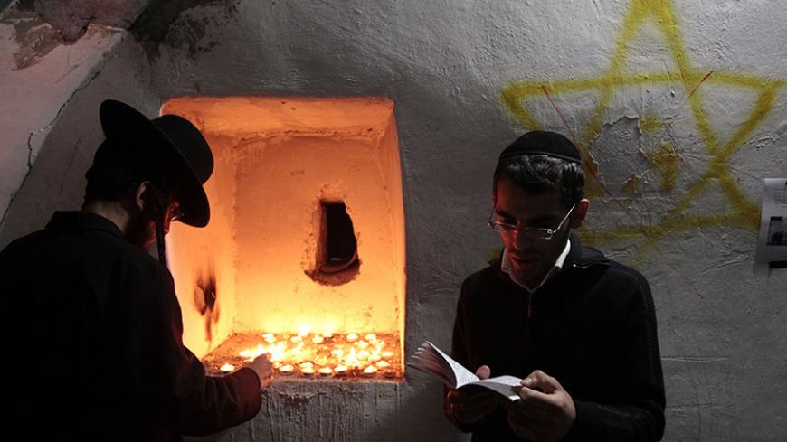 Ultra-Orthodox Jewish men pray in the Tomb of Joshua Ben Nun in the West Bank Arab village of Kifl Hares near the Jewish settlement of Ariel December 17, 2010. The Israeli army late on Thursday night allowed hundreds of ultra-Orthodox Jews to visit the Tombs of biblical figures, Joshua Ben Nun and Caleb Ben Yefuneh, on what is considered by many religious Jews as the biblical date of the anniversary of their death. REUTERS/Baz Ratner (WEST BANK - Tags: RELIGION) - RTXVTBD