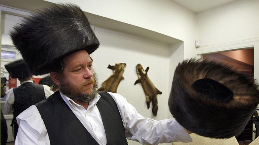 Moshe Lifschitz of Shtreichman Shtreimelech, holds a shtreimel or traditional fur hat worn by ultra-Orthodox Jews on festive occasions and holy days, at a shop in Jerusalem's Mea Shearim neighbourhood April 28, 2010. Israel may be the first country in the world to pass a bill banning fur trade within its borders, but ultra-Orthodox parliamentarians who fear it will impinge on religious freedom, are attempting to block the bill. Picture taken April 28, 2010. REUTERS/Baz Ratner (JERUSALEM - Tags: RELIGION POL