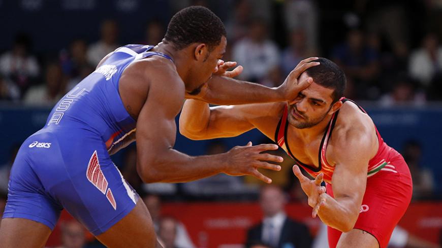 Jordan Ernest Burroughs of U.S. (in blue) fights with Iran's Sadegh Saeed Goudarzi on the final of the Men's 74Kg Freestyle wrestling at the ExCel venue during the London 2012 Olympic Games August 10, 2012.                  REUTERS/Suhaib Salem (BRITAIN  - Tags: OLYMPICS SPORT WRESTLING)   - RTR36MXD