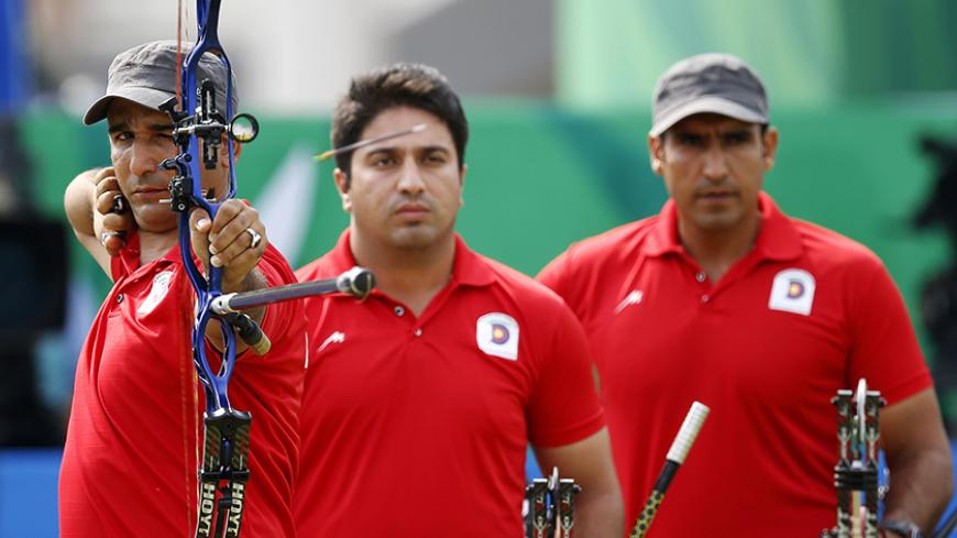 Iran's Esmaeil Ebadi shoots as teammates Majid Gheidi (C) and Amir Kazempour (R) watch during their men's compound team bronze medal archery match against the Philippines at the Gyeyang Asiad Archery Field during the 2014 Asian Games in Incheon September 27, 2014. REUTERS/Issei Kato (SOUTH KOREA - Tags: SPORT ARCHERY) - RTR47W41