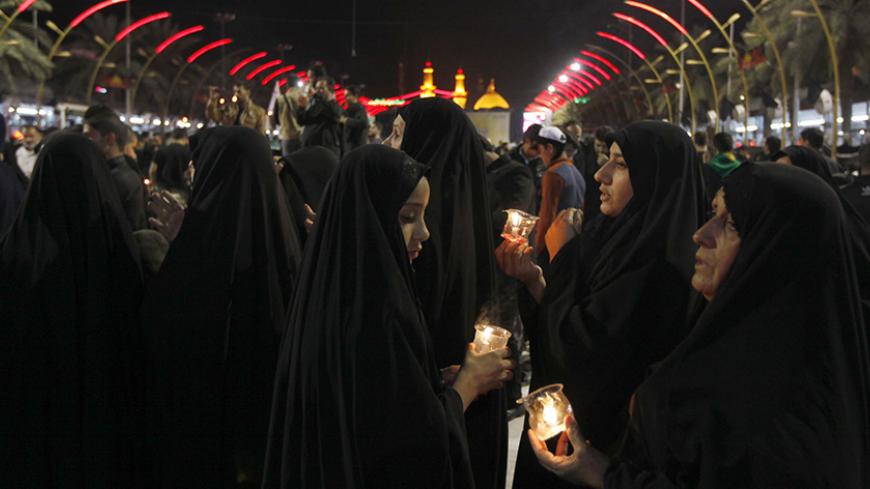 Muslim Shi'ite women light candles to commemorate Ashoura in Kerbala, southwest of Baghdad November 4, 2014. A gathering of millions of Shi'ite Muslims at shrines and mosques across Iraq for the Ashoura religious commemoration passed without any major attacks on Tuesday, under tight security imposed for fear of Islamic State bombers. REUTERS/Ahmed Saad (IRAQ - Tags: CIVIL UNREST POLITICS RELIGION) - RTR4CU6O