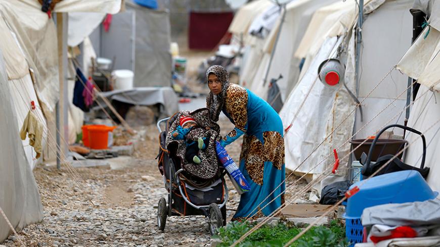 A Syrian refugee mother puts her baby to stroller in Nizip refugee camp, near the Turkish-Syrian border in Gaziantep province, Turkey, November 30, 2016. REUTERS/Umit Bektas - RTSU1P6