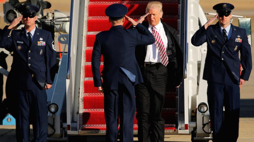 U.S. President Donald Trump salutes as he arrives aboard Air Force One at Joint Base Andrews, Maryland, U.S. January 26, 2017. REUTERS/Jonathan Ernst - RTSXJL3