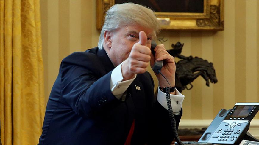 U.S. President Donald Trump gives a thumbs-up to reporters as he waits to speak by phone with the Saudi Arabia's King Salman in the Oval Office at the White House in Washington, U.S. January 29, 2017. REUTERS/Jonathan Ernst - RTSXXW0
