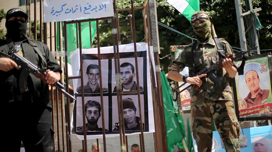 Palestinian Hamas militants stand guard during a rally marking Palestinian Prisoner Day, in Gaza City April 17, 2016. The sign reads, "The enemy will not know news about you unless it pays heavy prices." REUTERS/Mohammed Salem - RTX2AARA