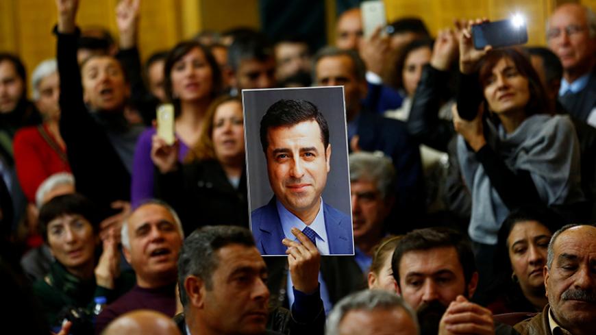 A supporter holds a portrait of Selahattin Demirtas, detained leader of Turkey's pro-Kurdish opposition Peoples' Democratic Party (HDP) at a meeting at the Turkish parliament in Ankara, Turkey, November 8, 2016, in the absence of Demirtas and other HDP lawmakers who were jailed after refusing to give testimony in a probe linked to "terrorist propaganda".  REUTERS/Umit Bektas - RTX2SH5T