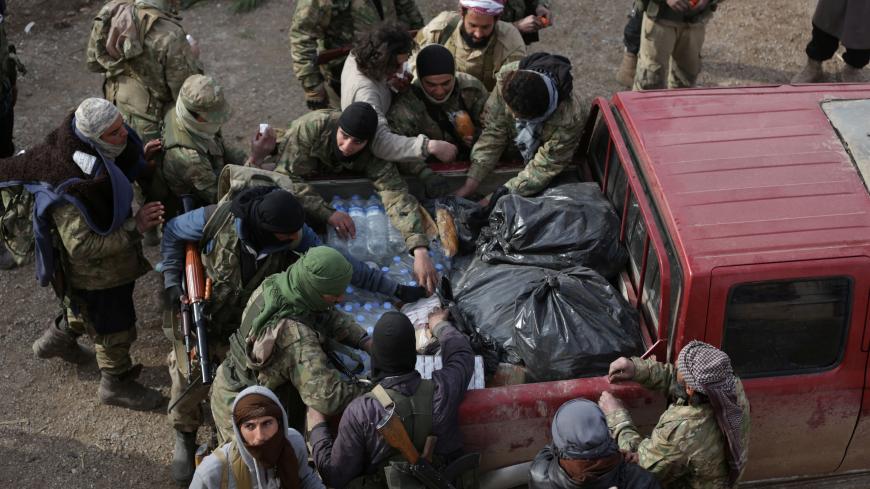 Rebel fighters gather around a pick-up truck carrying food on the outskirts of the northern Syrian town of al-Bab, Syria February 8, 2017. REUTERS/Khalil Ashawi - RTX306A0