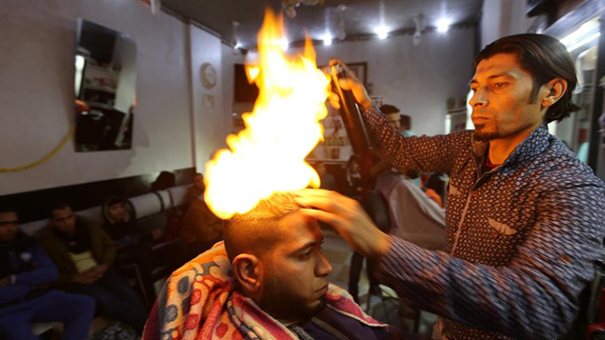 Palestinian barber Ramadan Odwan styles and straightens the hair of a customer with fire at his salon in Rafah, in the southern Gaza Strip February 2, 2017. Picture taken February 2, 2017.   REUTERS/Ibraheem Abu Mustafa       TPX IMAGES OF THE DAY - RTX309MG