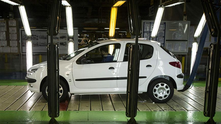 An Iranian technician sits in a Peugeot 206 car on the final production line at the Iran Khodro auto plant, west of Tehran, on February 20, 2016. / AFP / BEHROUZ MEHRI        (Photo credit should read BEHROUZ MEHRI/AFP/Getty Images)