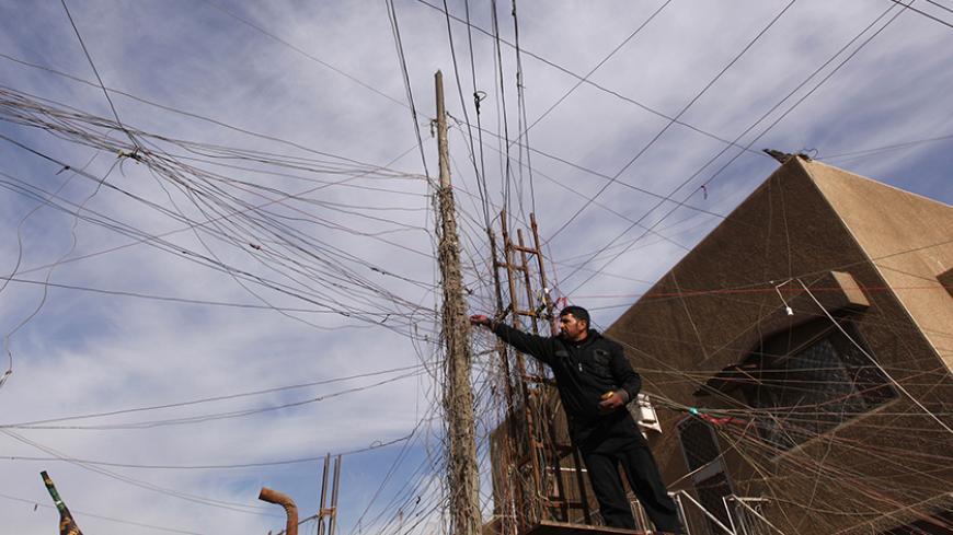 An electrician uses an Avometer to check wires connected to his local generator on a street in Baghdad, December 13, 2011. Iraq's financial system is slowly embracing the free market after years of tight control under Saddam; a fledging stock market is attracting foreign money while the banking and telecommunications industries are growing rapidly. But the national grid provides only a few hours of intermittent power a day, forcing Iraqis to live off noisy diesel-fueled generators. Picture taken December 13