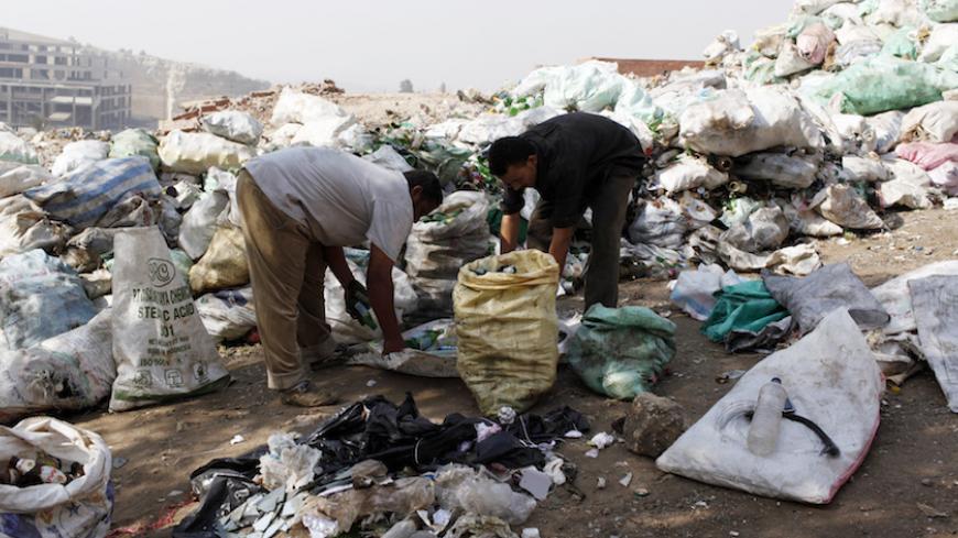 Men look through rubbish in a garbage dump in Zabbaleen in Cairo October 11, 2012. The Zabbaleen, which means "garbage people", have served as informal garbage collectors for approximately the past 70 to 80 years, living in the nicknamed area "Garbage City". Their community has a population of around 20,000 to 30,000, over 90 percent of which are Coptic Christians. For several generations, the Zabbaleen supported themselves by collecting trash door-to-door from residents for little money and they recycle up