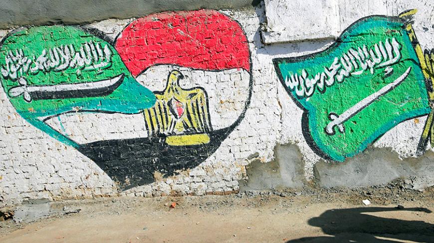 The shadows of men walking are seen in front of graffiti depicting relations between Egypt and Saudi Arabia in Cairo, Egypt, October 12, 2016. Picture taken October 12, 2016. REUTERS/Amr Abdallah Dalsh - RTSS9QV