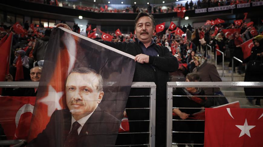A supporter of Turkish President Recep Tayyip Erdogan holds a flag before Turkish Prime Minister Binali Yildirim is expected to address a crowd of around 10,000 in Oberhausen, Germany, February 18, 2017, to promote Turkey's constitution referendum on April 16, 2017.     REUTERS/Wolfgang Rattay    - RTSZ91P