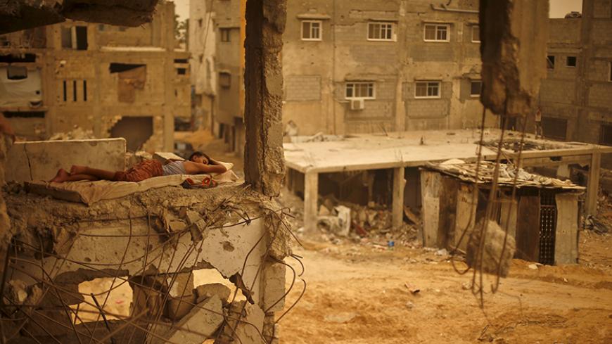 A Palestinian boy sleeps on a mattress inside the remains of his family's house, which witnesses said was destroyed by Israeli shelling during a 50-day war in 2014 summer, during a sandstorm in Gaza September 8, 2015. A heavy sandstorm swept across parts of the Middle East on Tuesday, killing two people and hospitalising hundreds in Lebanon and disrupting fighting and air strikes in neighboring Syria. Clouds of dust also engulfed Israel, Jordan and Cyprus where aircraft were diverted to Paphos from Larnaca 